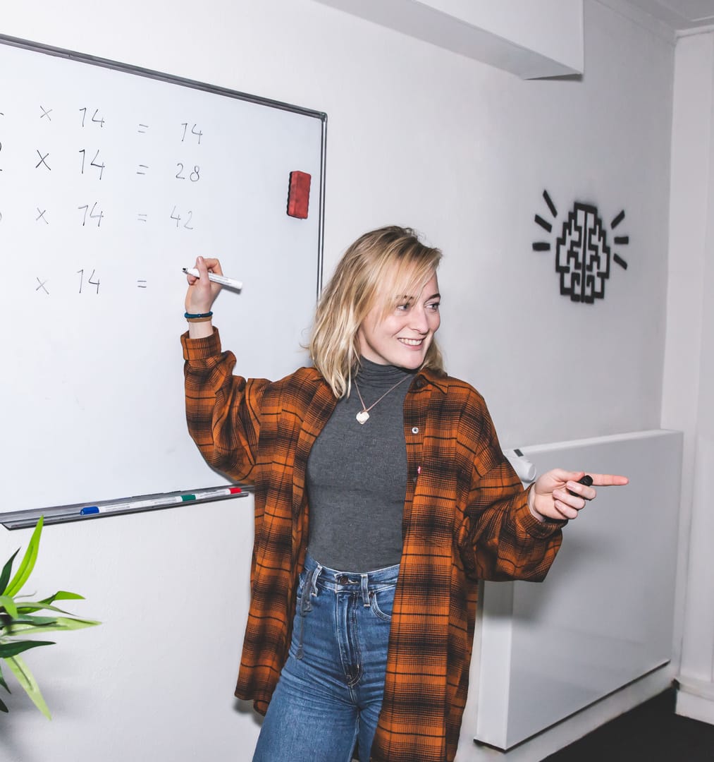 Brainboost docent schrijft vermenigvuldigingstafels op whiteboard tijdens wiskunde bijles